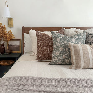 Agnes, Lenora, Esme, Callum, and Caspian lumbar pillow covers set on a beautiful bed with white quilt and beige throw blanket.