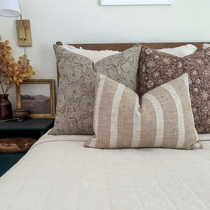 Agnes, Mae, and Caspian lumbar pillow covers form Colin and Finn on neutral bed with side table covered with fall florals.