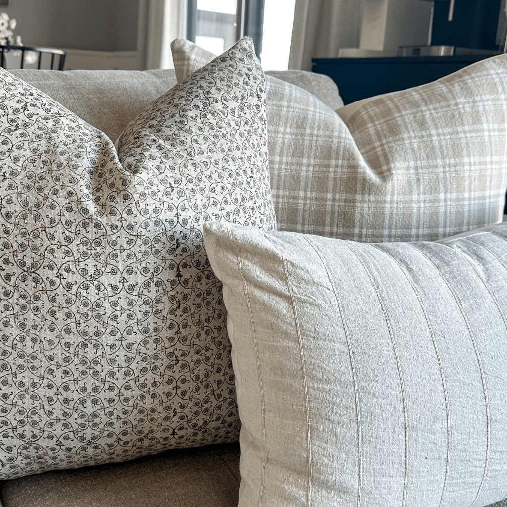 A close up of Beatrice, Copeland, and Logan Lumbar on a grey sofa