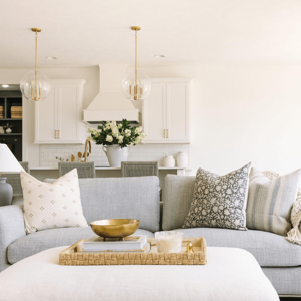 A living room with a gray couch and three pillows, Dara, Sawyer, and Felicity