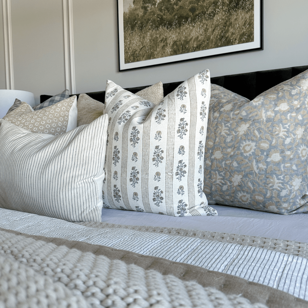 Kennedy, Leighton, and Laney Lumbar on a bed with a black headboard