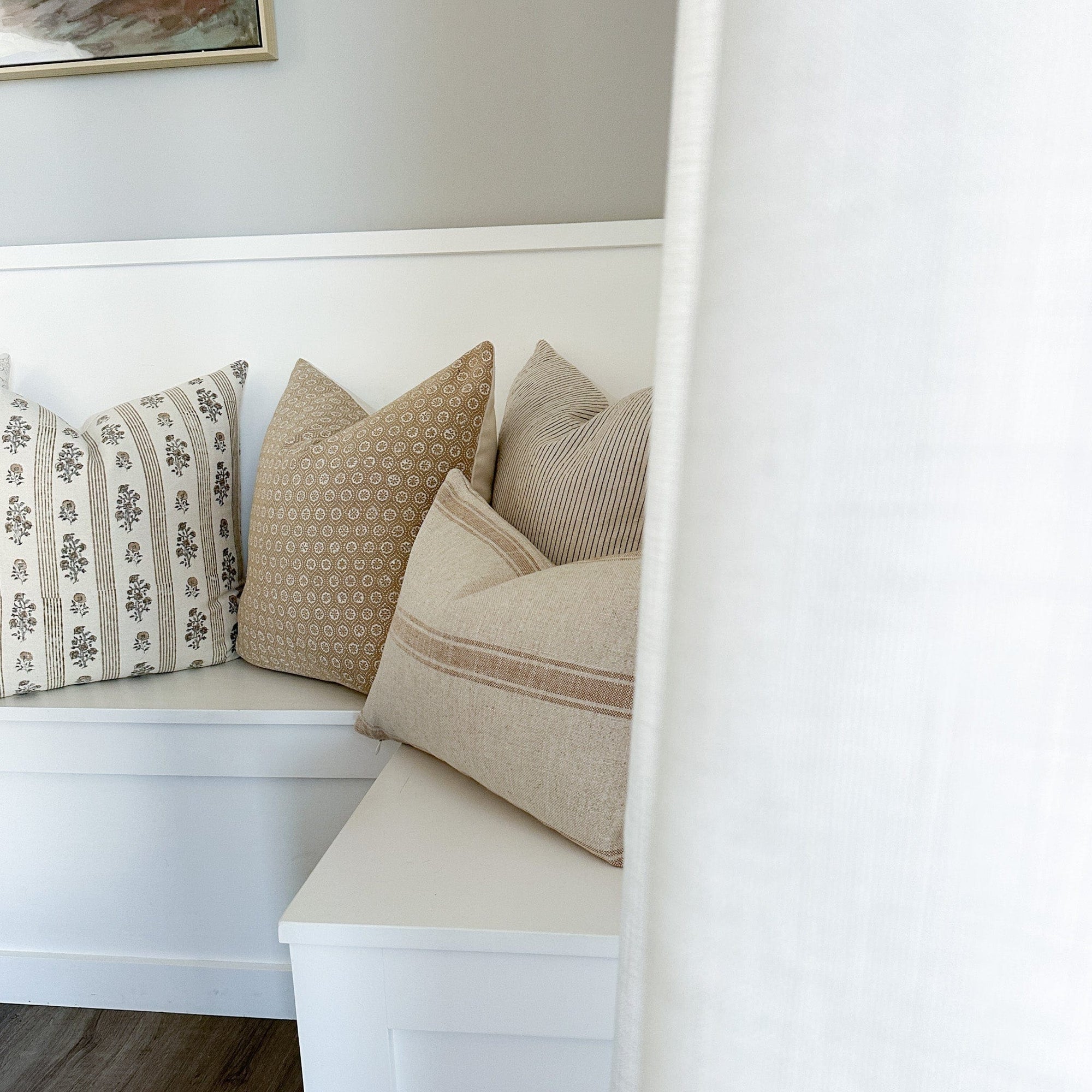 Arizona lumbar, Laney, Matilda, and Leighton pillow covers from Colin and Finn on white kitchen bench with white drapes in front of them.