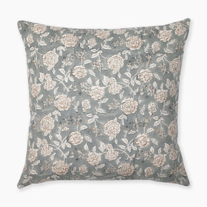 A square pillow with a light blue-green background features an intricate pattern of white and beige roses with green leaves and small brown branches. The floral design is spread evenly across the entire surface of the pillow.