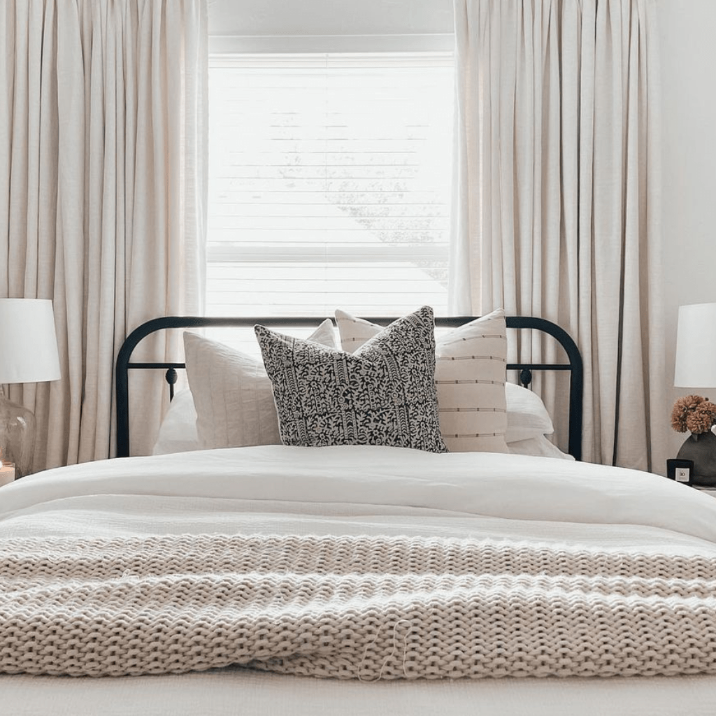 A closeup of Madison, Logan, and Rory pillows on a bed in front of a window