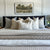 Colin and Finn throw pillow set on a neutral bed with black headboard and natural photo above the headboard.