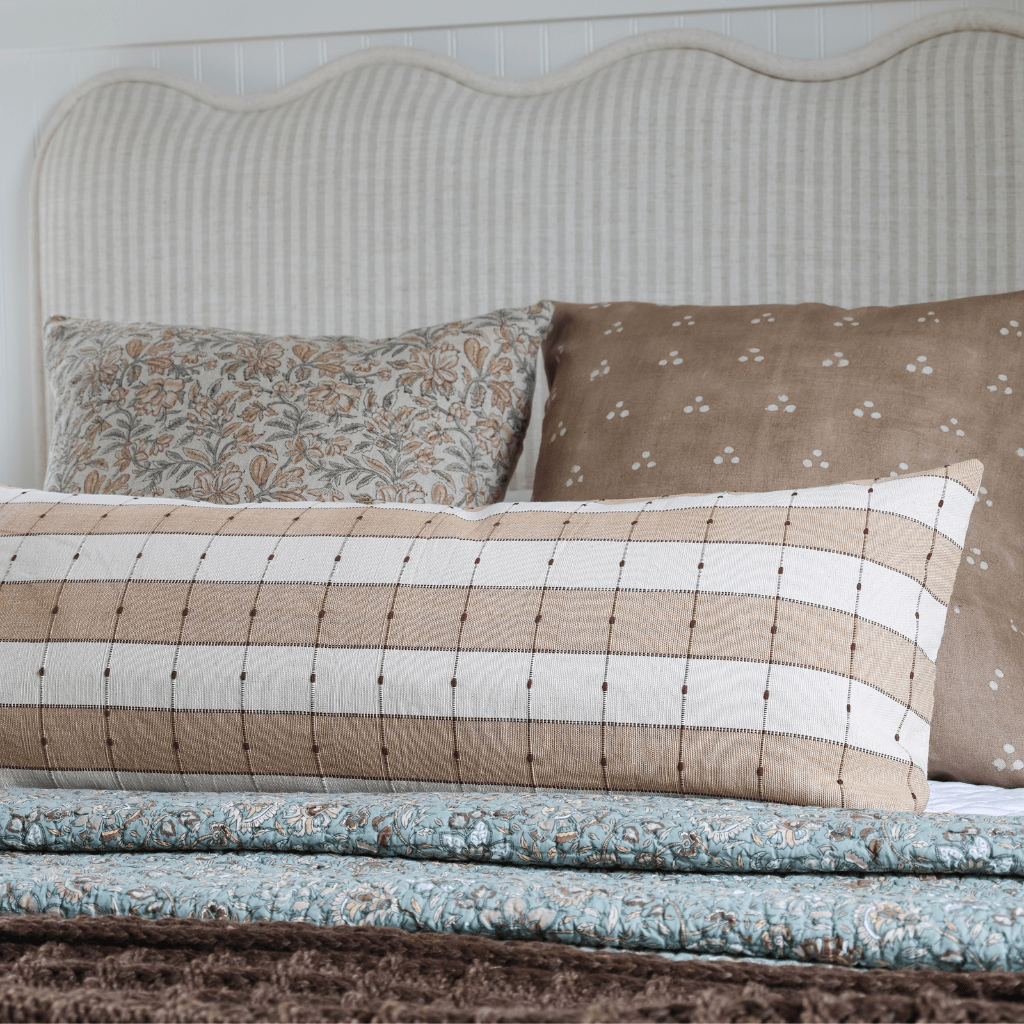 Prescott, Elain, and Emberly on a bed with a white headboard and a blue and brown blanket