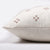 Side view of Dara pillow cover showing invisible zipper, rust crosses on ivory front, and solid ivory back.