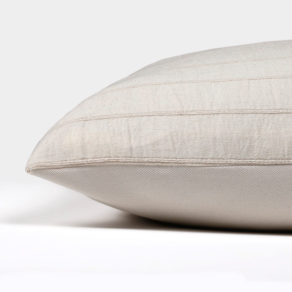 Side view of the Logan pillow cover from Colin and Finn showing the ivory cotton stripes on the front and the solid ivory backing on the back.