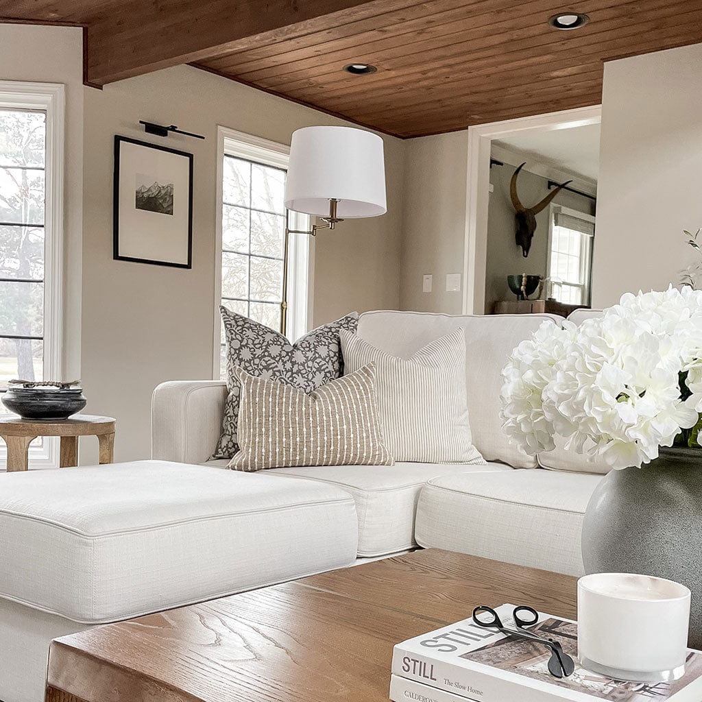 Bardot burlap lumbar pillow cover from Colin and Finn with Sawyer and Laney on white chaise sofa with wood panel ceiling.