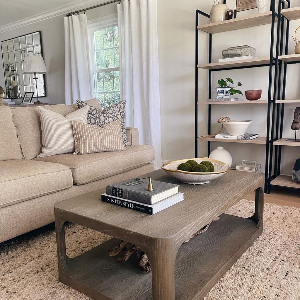 Conyer Pillow Combo sitting on a beige sofa in a living room. A light brown coffee table with books and a bowl sitting on it.